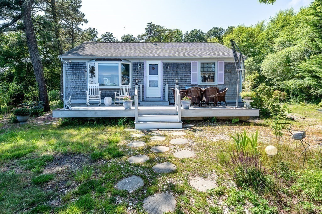 41 Aunt Debby's Road Dennis Port, MA 02639 - Photo 9 of 42 a front view of a house with a yard table and chairs