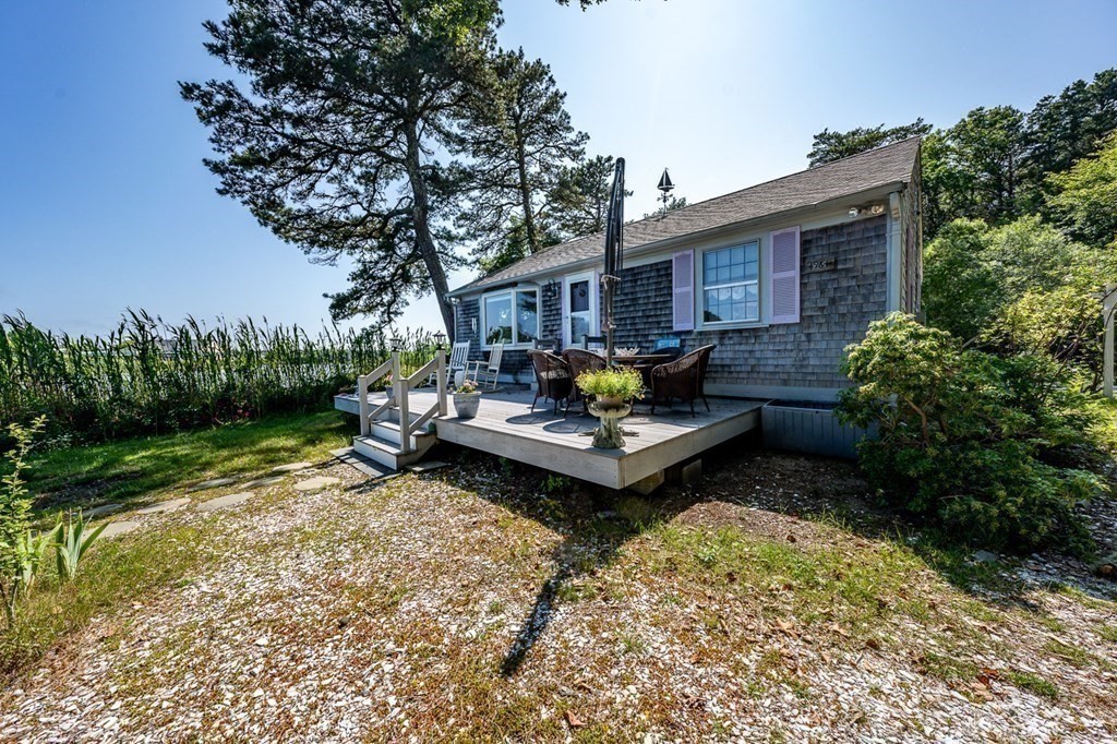 41 Aunt Debby's Road Dennis Port, MA 02639 - Photo 10 of 42 a view of a backyard with table and chairs potted plants and a large tree