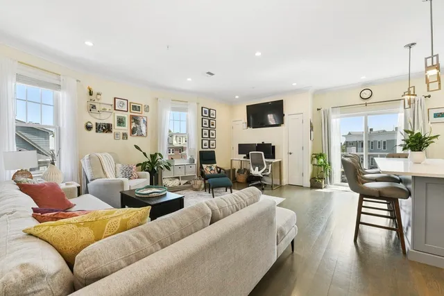 a living room with furniture and a flat screen tv with wooden floor