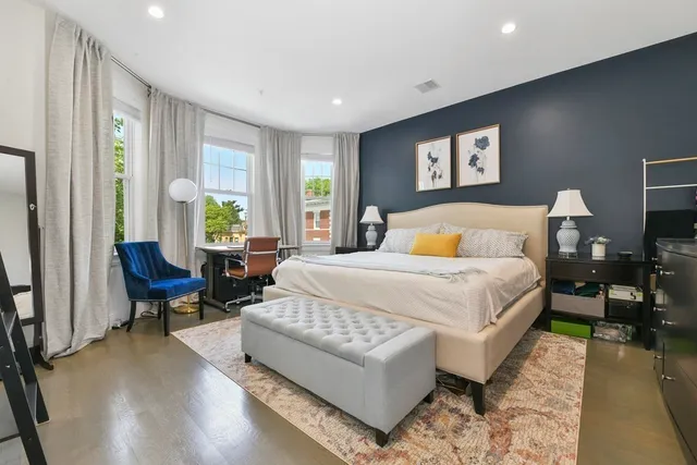 a bedroom with a bed a couch and a window