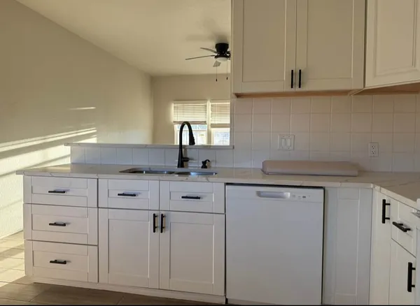 a kitchen with white cabinets and white appliances