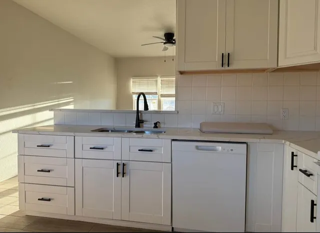 a kitchen with white cabinets and white appliances
