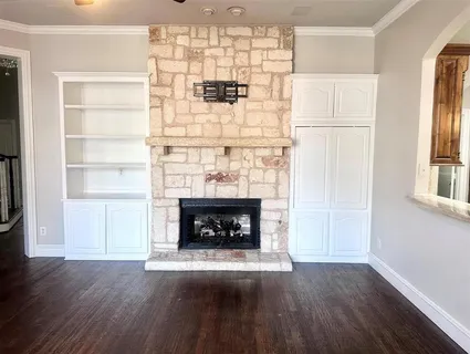 a view of wooden floor fire place and windows in a room