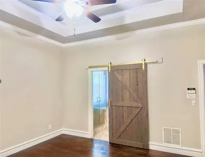 a room with wooden floor closet and windows