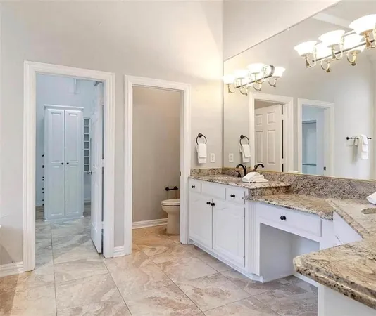 a spacious bathroom with a granite countertop sink a mirror and a shower