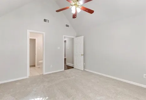a view of an empty room and chandelier fan