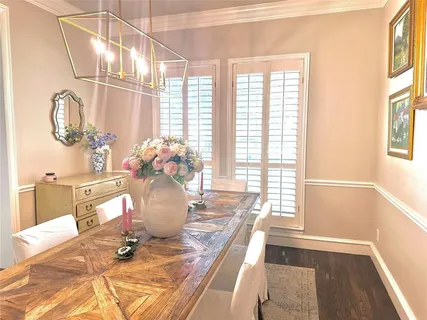 a dining room with wooden floor and a chandelier