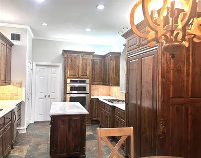 a kitchen with a refrigerator and a stove top oven