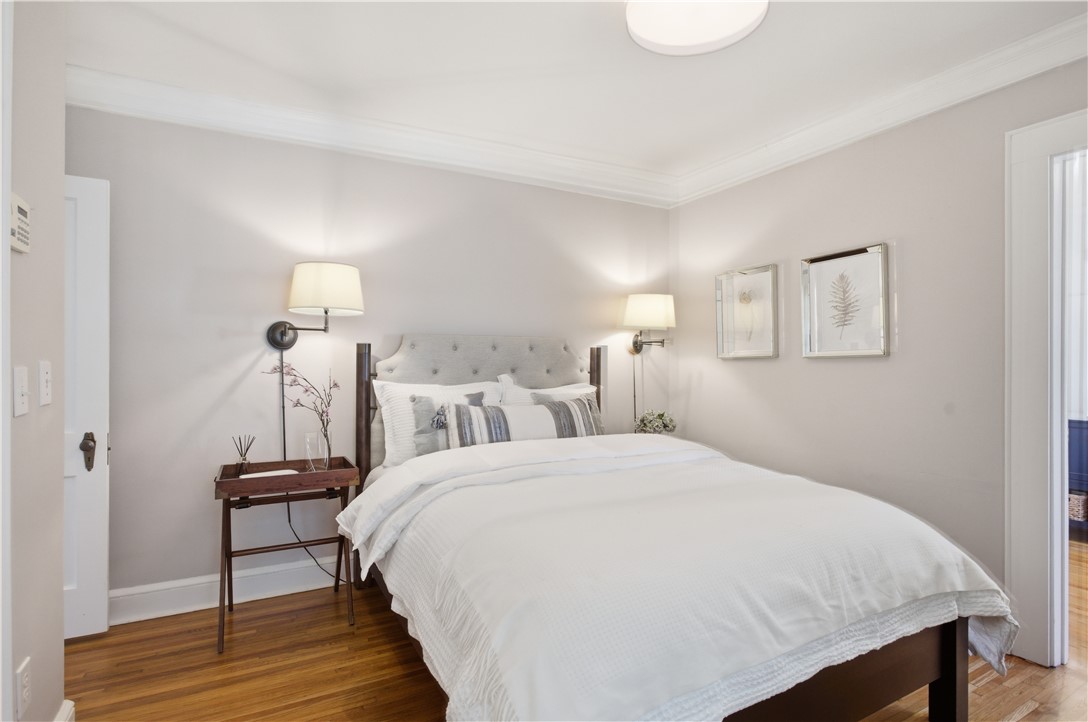 310 Retreat Street Westminster, SC 29693 - Photo 8 of 46 This cozy bedroom features hardwood floors and elegant crown molding, creating a serene and inviting atmosphere.