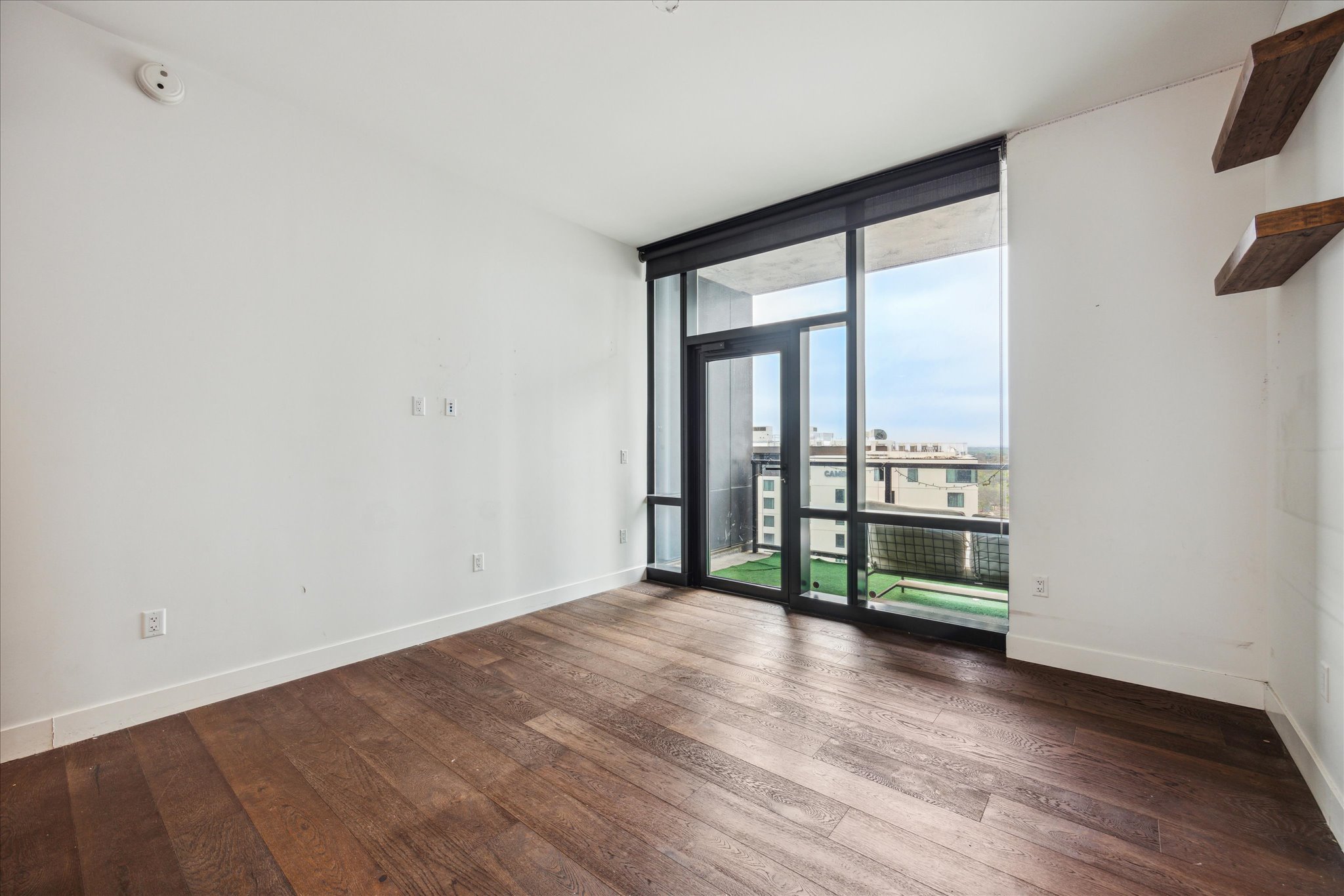 70 Rainey Street, Unit 1405 Austin, TX 78701 - Photo 2 of 31 an empty room with wooden floor and windows