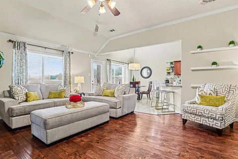 a living room with furniture and a wooden floor