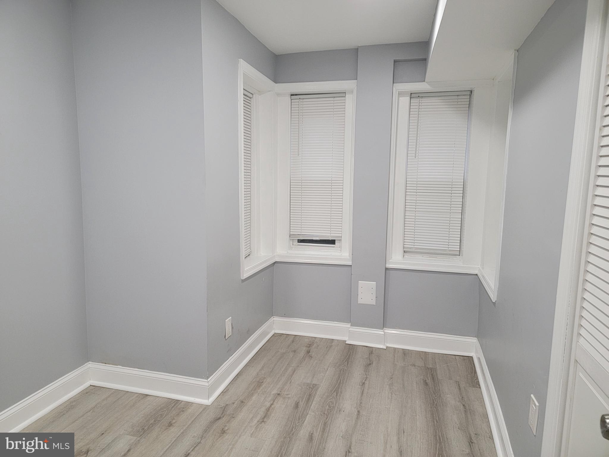 a view of empty room with wooden floor
