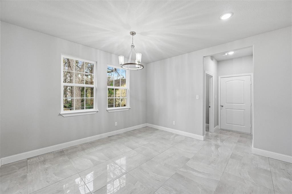 306 Lewis Street Cleburne, TX 76031 - Photo 9 of 20 en empty room with windows and chandelier
