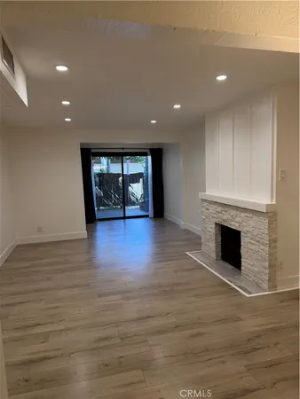 an empty room with wooden floor and fireplace
