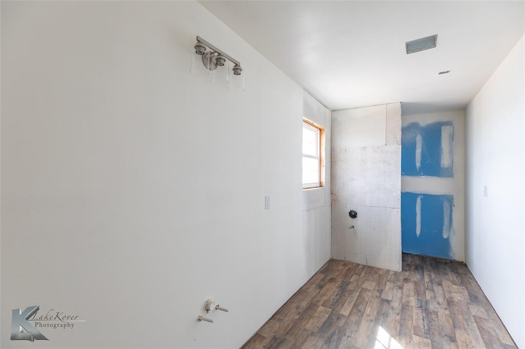 8773 West Lake Road Abilene, TX 79601 - Photo 25 of 40 an empty room with wooden floor and windows