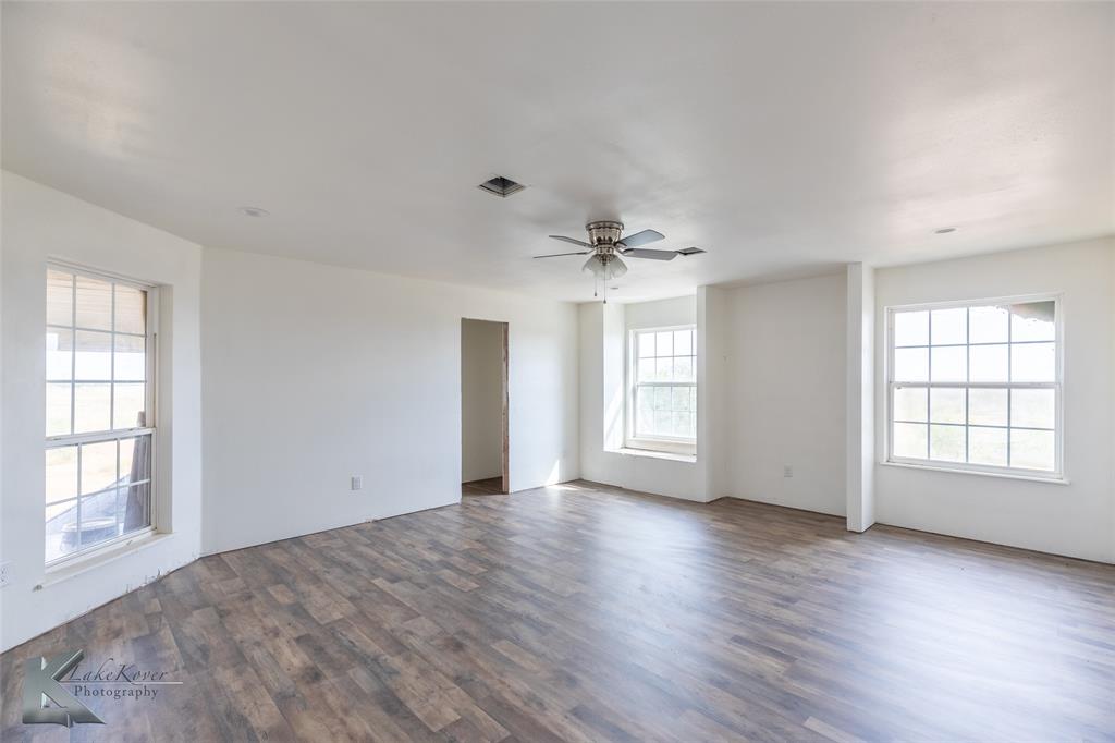 8773 West Lake Road Abilene, TX 79601 - Photo 27 of 40 an empty room with wooden floor and windows