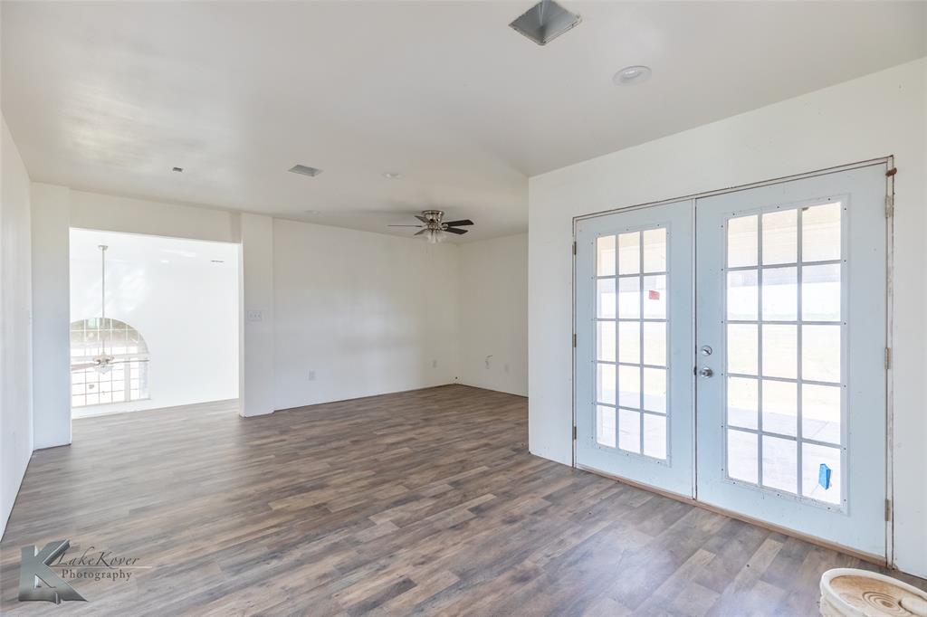 8773 West Lake Road Abilene, TX 79601 - Photo 28 of 40 an empty room with wooden floor and windows