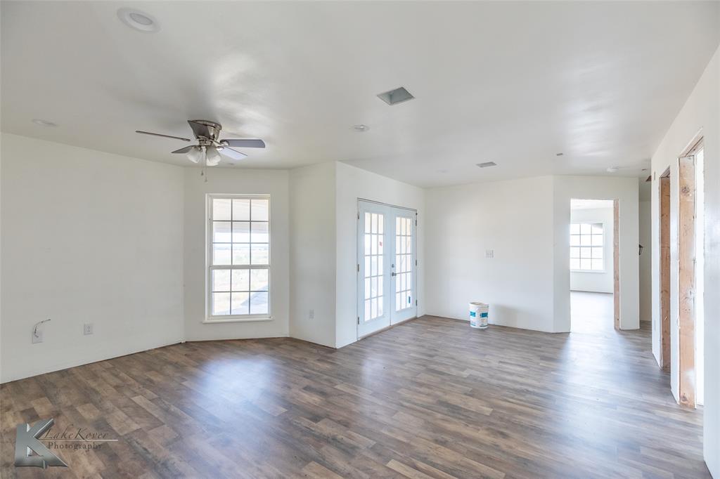 8773 West Lake Road Abilene, TX 79601 - Photo 29 of 40 a view of an empty room with a window and wooden floor