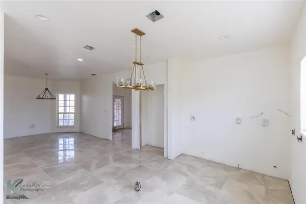 a view of a room with a window and chandelier fan