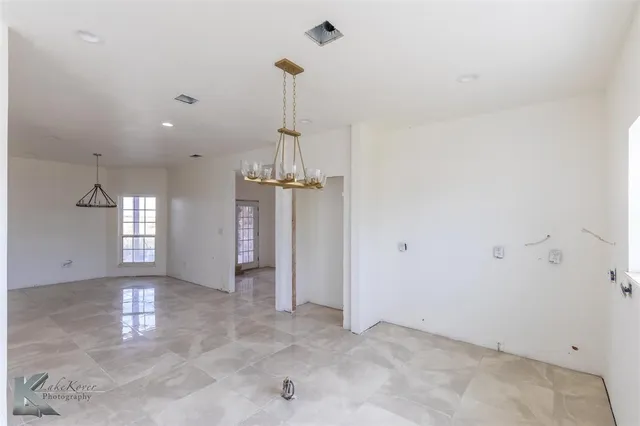 a view of a room with a window and chandelier fan
