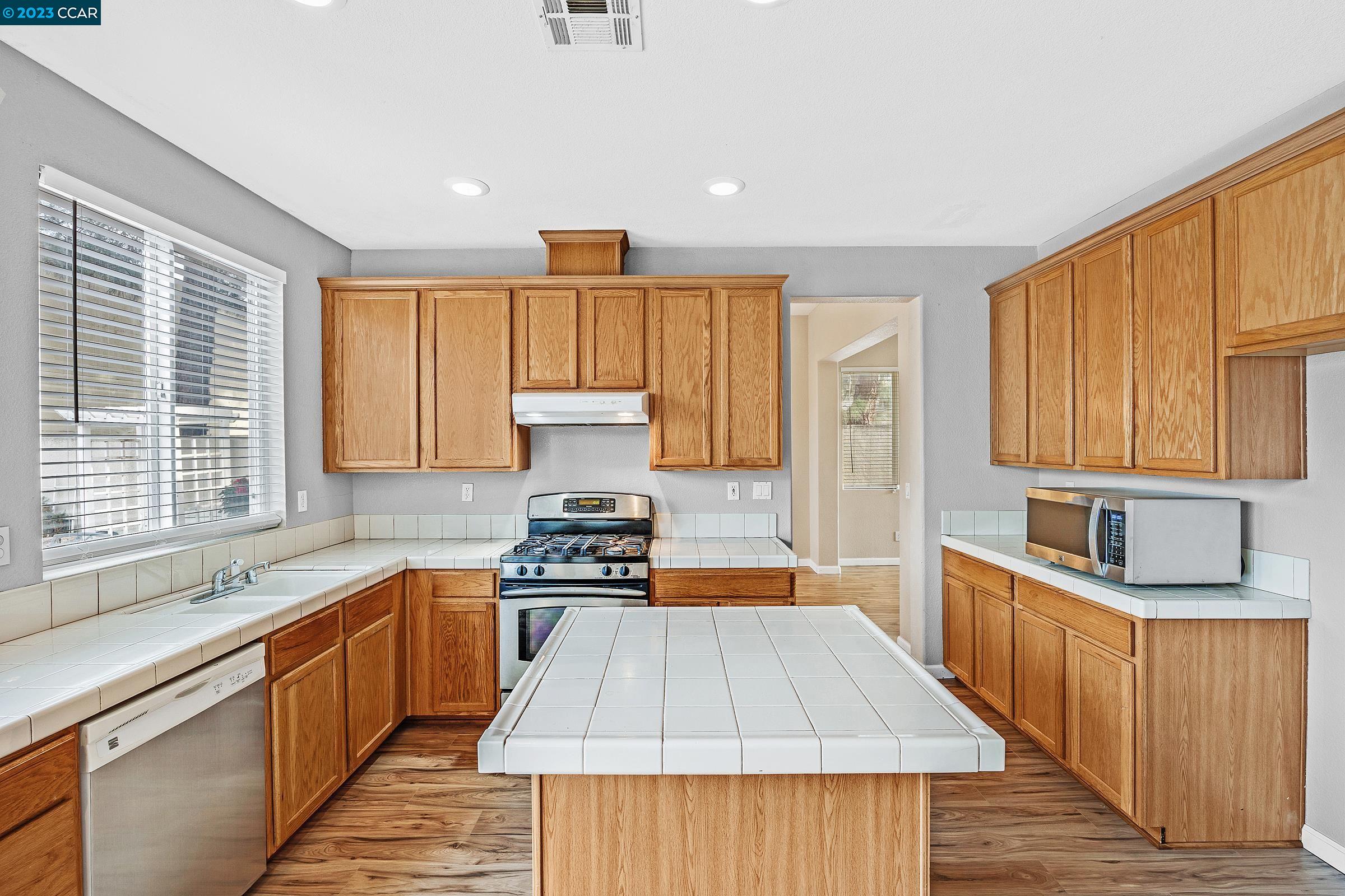 20 West 6th Street Pittsburg, CA 94565 - Photo 8 of 15 a kitchen with stainless steel appliances a stove a sink and a refrigerator