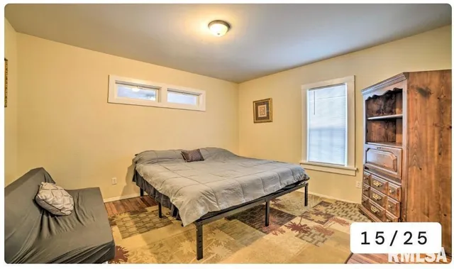 a bedroom with a bed and a refrigerator