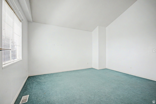 2058 California Avenue, Unit 2 Provo, UT 84606 - Photo 8 of 32 Spacious interior room featuring a large window with horizontal blinds, light-colored walls, and green carpet flooring