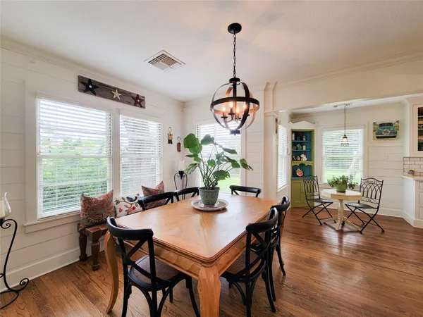 a view of a dining room and livingroom with furniture wooden floor a chandelier