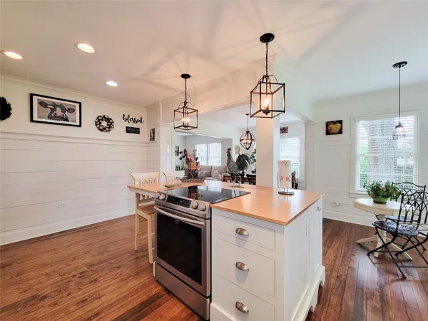a kitchen with a stove and wooden floor