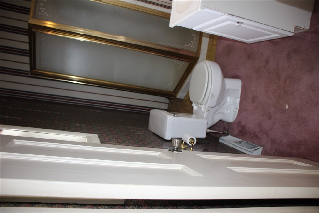 402 Canaan Road Marshall, AR 72650 - Photo 24 of 37 Functional bathroom featuring a two-piece toilet, pedestal sink, and burgundy carpet flooring