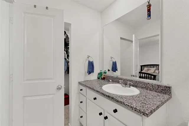 a bathroom with a granite countertop sink and a mirror