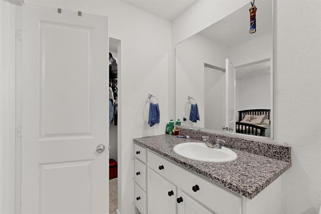 918 Grebe Drive Princeton, TX 75407 - Photo 16 of 29 a bathroom with a granite countertop sink and a mirror