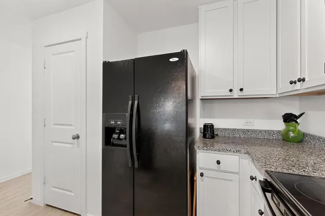a kitchen with refrigerator and cabinets