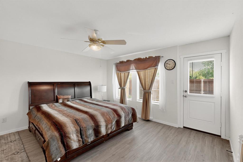 918 Grebe Drive Princeton, TX 75407 - Photo 24 of 29 a bedroom with a large bed and a chandelier