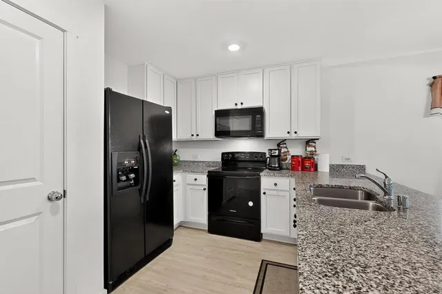 a kitchen with stainless steel appliances granite countertop a refrigerator stove and microwave