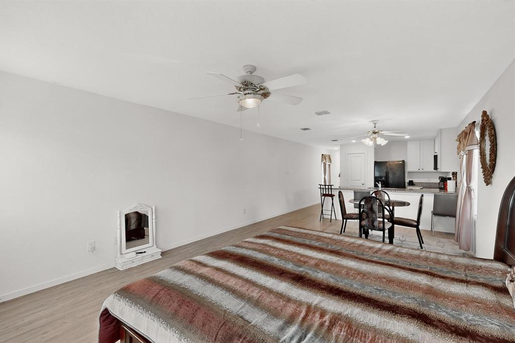 918 Grebe Drive Princeton, TX 75407 - Photo 28 of 29 a bedroom with a bed and a chandelier