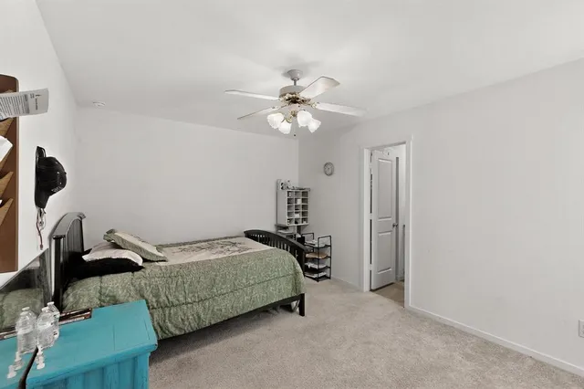 a bedroom with a bed and a ceiling fan