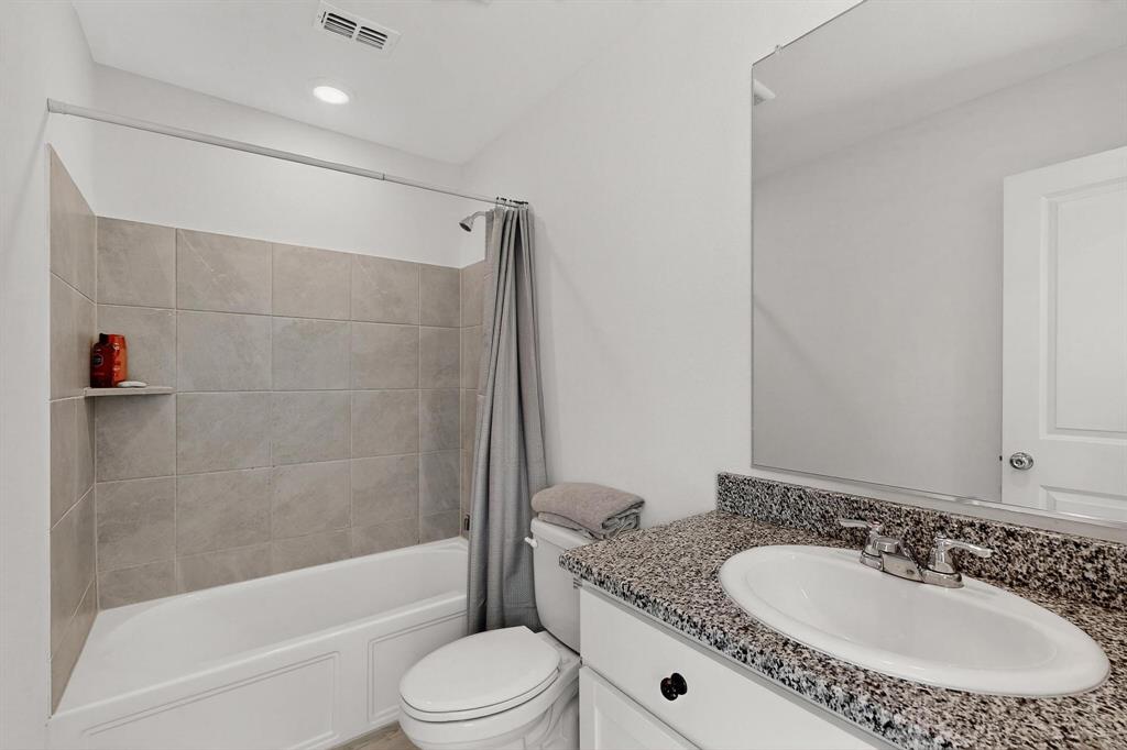 918 Grebe Drive Princeton, TX 75407 - Photo 9 of 29 a bathroom with a granite countertop sink a toilet a mirror and shower