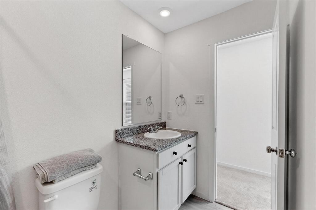 918 Grebe Drive Princeton, TX 75407 - Photo 10 of 29 a bathroom with a granite countertop sink and a mirror