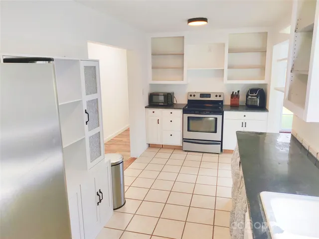 a kitchen with a stove a refrigerator and cabinets