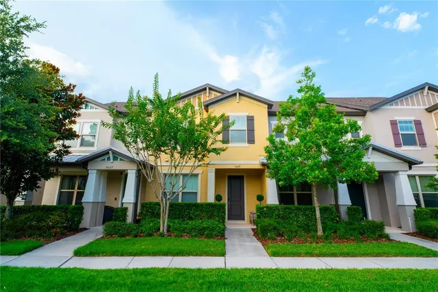 a front view of a house with a yard and trees