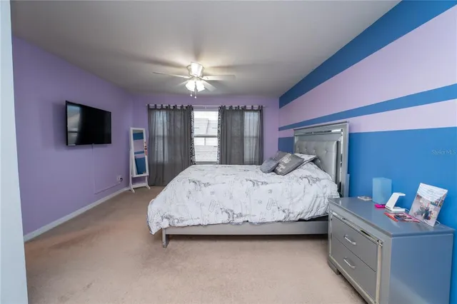 a spacious bedroom with a bed and a chandelier