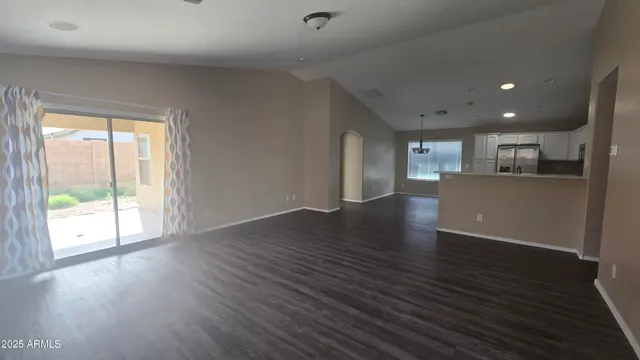 a view of a big room with wooden floor and windows