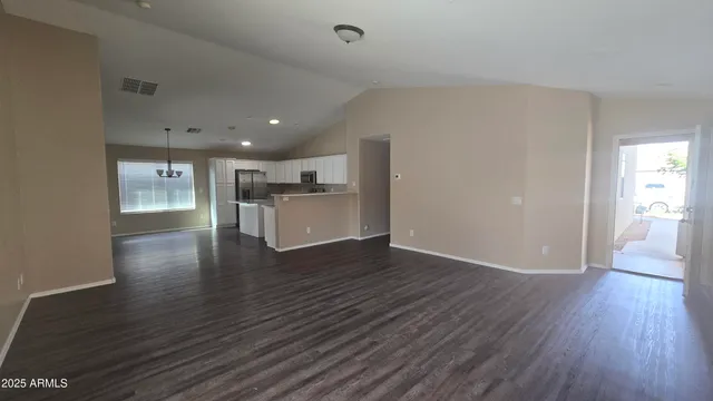 a view of a kitchen with a fridge and wooden floor