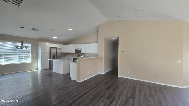 a view of a kitchen with wooden floor and a window