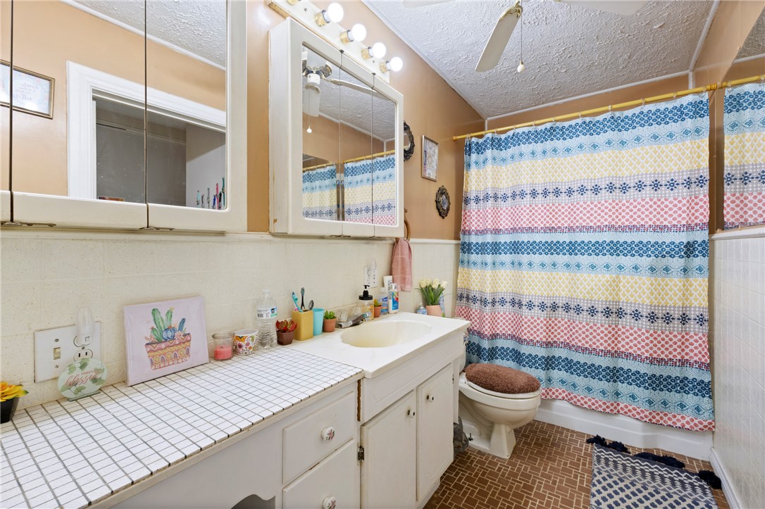 1007 South Magnolia Street Hearne, TX 77859 - Photo 12 of 25 a bathroom with a sink a toilet and shower