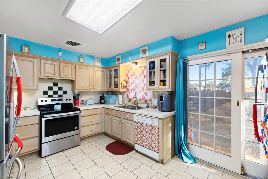 1007 South Magnolia Street Hearne, TX 77859 - Photo 14 of 25 a kitchen with stainless steel appliances granite countertop a sink stove and refrigerator