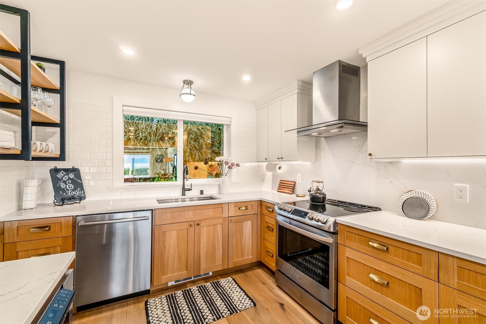 10203 47th Avenue Southwest, Unit D2 Seattle, WA 98146 - Photo 9 of 36 a kitchen with stainless steel appliances a sink stove and cabinets