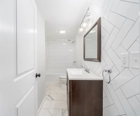 a bathroom with a sink a toilet and mirror