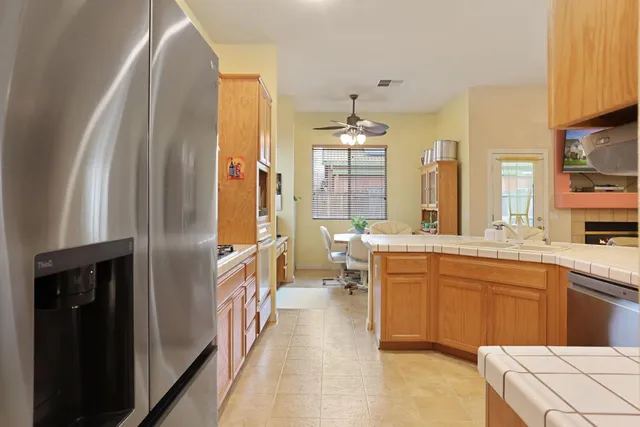 a kitchen with stainless steel appliances kitchen island granite countertop a dining table and chairs